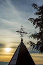 Christian church steeple cross isolated against the blue partially cloudy sky at sunset. Royalty Free Stock Photo