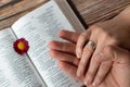 Christian couple hands with rings holding in prayer over open Holy Bible Book placed on wooden background, top view Royalty Free Stock Photo