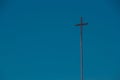 Christian cross against blue sky. Religious background. Copy space for text. Religion symbol. Faith concept