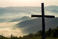 Christian cross on a background of fog-covered mountains at dawn Royalty Free Stock Photo