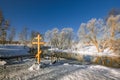 Christian cross on the coast of the winter river Royalty Free Stock Photo