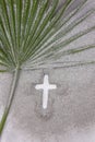 Christian Cross drawing in ash with palm leaf. Concept for Lent Season, Holy Week, Palm Sunday and Good Friday. Flat lay. Royalty Free Stock Photo