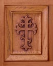 Christian cross etched in wooden door panel