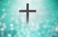 The Christian cross looks bright in soft white and the glittering bokeh background is the light of hope and leads to heaven.