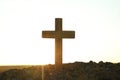 Christian cross outdoors at sunrise. Religion concept