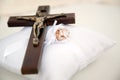 Christian cross and wedding rings on white cushion Royalty Free Stock Photo