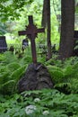 Christian cross in wild thickets of green vegetation in the old cemetery Royalty Free Stock Photo