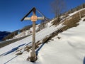 Christian crucifix on the Way of the Cross next to the monastery in a winter atmosphere over the Alpine valley Obertoggenburg