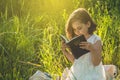 Christian girl holds bible in her hands. Reading the Holy Bible in a field during beautiful sunset. Concept for faith Royalty Free Stock Photo