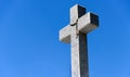 Christian granite cross on blue sky background with copy space Royalty Free Stock Photo