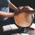 Christian group praying for globe and people around the world on wooden table with bible. Christian small group praying together Royalty Free Stock Photo