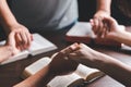 Christian group praying for globe and people around the world on wooden table with bible. Christian small group holding hands and Royalty Free Stock Photo