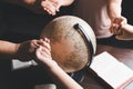 Christian group praying for globe and people around the world on wooden table with bible. Christian small group holding hands and Royalty Free Stock Photo