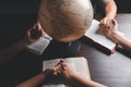 Christian group praying for globe and people around the world on wooden table with bible. Christian small group holding hands and Royalty Free Stock Photo