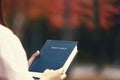 Christian holding a bible in an autumn maple forest