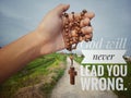 Christian inspirational quote - God will never lead you wrong. With junior hand holding wooden rosary with Jesus Christ cross