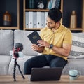 Christian man, bible and study with phone and microphone online while live streaming. Asian male on home sofa with holy Royalty Free Stock Photo