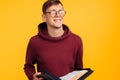 Christian man with glasses holds a Bible in his hands. Bible reading over isolated yellow background. Faith Royalty Free Stock Photo