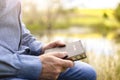 Christian man holding the Holy Bible at sunset by water and field background Royalty Free Stock Photo