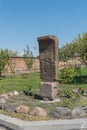 Armenia, Echmiadzin, September 2021. Ancient khachkar on a flower bed in the park.