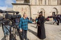 Christian priest gives a television interview near the Svetitskhoveli Cathedral, built in 4th century