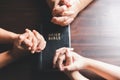 Christian small group praying together around a wooden table with bible page in homeroom. Christian group praying for globe and Royalty Free Stock Photo
