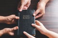 Christian small group praying together around a wooden table with bible page in homeroom. Christian group praying for globe and Royalty Free Stock Photo