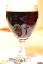 A Christian symbols of a communion - the cross and pieces of a bread are mirrored in a glass chalice of red wine.