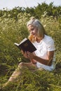 Christian teenage girl reading the Bible in the field. Faith, spirituality and religion concept Royalty Free Stock Photo