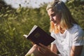 Christian teenage girl reading the Bible in the field. Faith, spirituality and religion concept Royalty Free Stock Photo