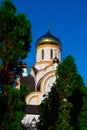 Christian white church at sunny summer day and thuja trees