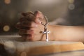 Christian woman hand on holy bible worship to god holding cross rosary