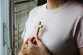Christian woman holding a wooden cross against her chest while praying God protect Royalty Free Stock Photo