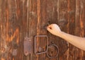 Christian woman`s hand knocking on an old wooden door. Seek and find God and Jesus Christ. Royalty Free Stock Photo