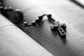Christian wooden crucifix on open bible, point focus. Religious concept image, black and white image