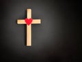 Christianity Concept - Wooden cross shaped with red heart shaped background. Stock photo.