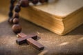 Christianity, religion, faith concept. Close up rosary cross against Bible background as a symbol of victory over death