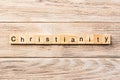 Christianity word written on wood block. christianity text on table, concept