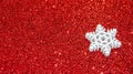 Christmas abstract background. Abstract bokeh lights. Shiny sparkle metallic glitter texture. White decorative snowflake on a red Royalty Free Stock Photo