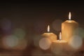 Christmas advent candle light in church with blurry golden bokeh for religious ritual or spiritual zen meditation, peaceful mind Royalty Free Stock Photo