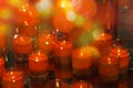 Christmas advent candle light in a small glass in church with blurry golden bokeh for religious ritual or spiritual zen meditation Royalty Free Stock Photo