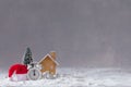 Christmas alarm clock, Santa Claus hat, small wooden toy cottage and fir-tree with balls, postcard concept