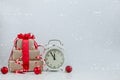 Christmas alarn clock, balls and gift boxes. Light snow background. Holidays, celebration and presents concept