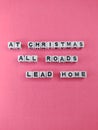 At Christmas all roads lead home heart warming Christmas saying on a pink background Royalty Free Stock Photo