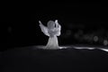 christmas angel on blur bokeh city lights at night on background. Little white guardian angel in snow Royalty Free Stock Photo