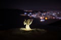 christmas angel on blur bokeh city lights at night on background. Little white guardian angel in snow Royalty Free Stock Photo