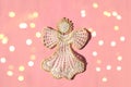 Christmas angel knitted bauble on pink New Year background with bright lights, flat lay, top view Royalty Free Stock Photo