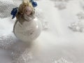 Christmas angel toy across white background with snowflakes. Royalty Free Stock Photo