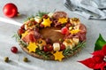 Christmas appetizers wreath on wooden board and grey background, star of Christmas plant or Poinsettia, napkin, forks