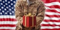Christmas in the army. Christmas ball and gift box on an American military uniform Royalty Free Stock Photo